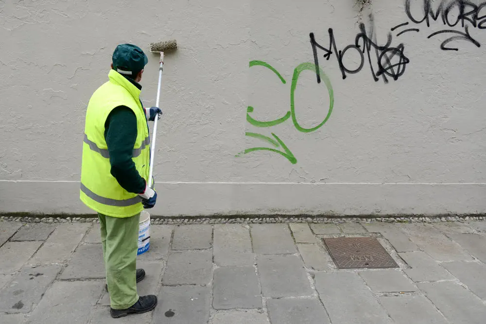 Malermeister überstreicht Graffiti